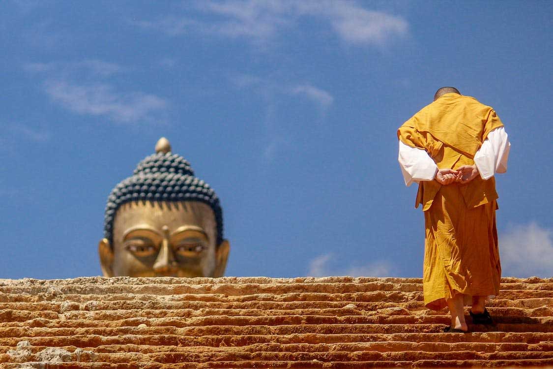 monk heading to buddha satue